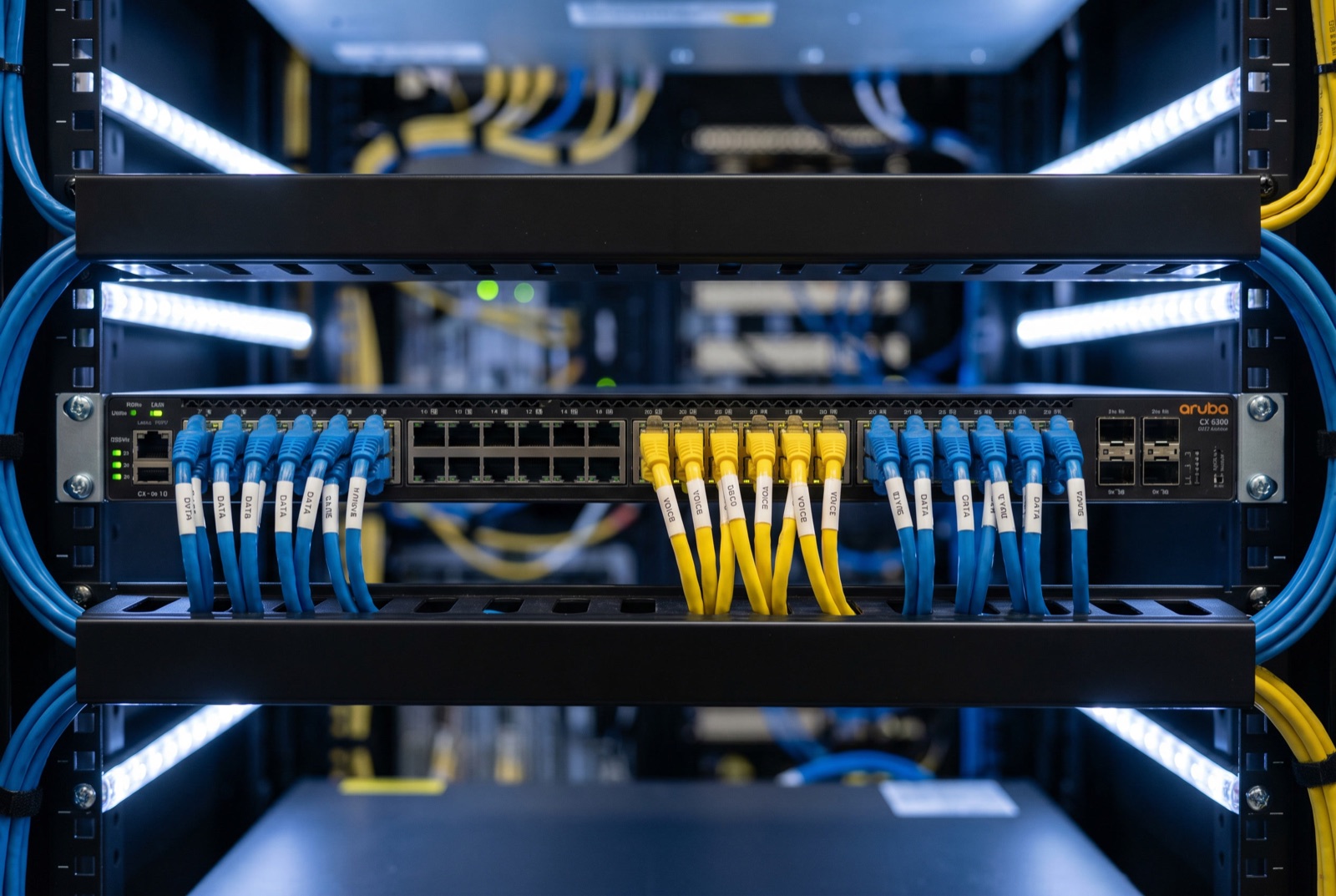 Aruba CX 6300 switch with labelled colour-coded Cat6A patch leads